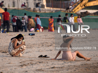 A woman poses for a mobile phone photograph near a sea beach in Mumbai, India, 04 January, 2023. Smartphone flattens internet growth curve i...