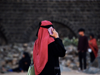A muslim woman talks on a phone near a sea beach in Mumbai, India, 04 January, 2023. Smartphone flattens internet growth curve in India acco...