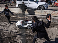 Boys smash a toy car on the street of the Old City in Jerusalem, Israel on December 29, 2022. (