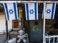 Teddy bears wearing a face masks are seen with Israeli flags near Carmel Market (Shuk Ha'Carmel) in in Tel Aviv, Israel on December 30, 2022...