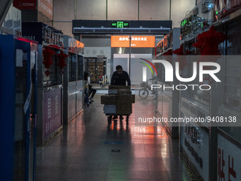 A worker pushing a cart next to closed store inside a shopping center in Huaqiangbei, a popular place to buy electronic goods on January 8,...