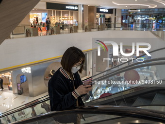 A women wearing a face mask riding an escalator inside a shopping mall on January 8, 2023 in Shenzhen, China. China today lifts its requirem...