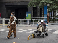 People wearing a face mask walking down a street on January 8, 2023 in Shenzhen, China. China today lifts its requirement for inbound travel...