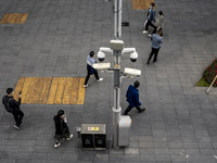 People walking pass security cameras on January 8, 2023 in Shenzhen, China. China today lifts its requirement for inbound travelers to under...
