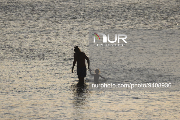 A man with a child is seen in water by Charles Clore Beach at the Mediterranean Sea in Tel Aviv, Israel on December 30, 2022. 