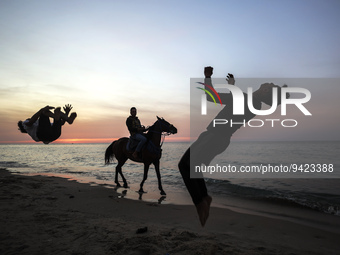 Palestinian youths jump in front of Gaza Beach and practice Parkour skills during sunset, , on January 11, 2023.  (