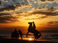 A Palestinian youth on his horse take during sunset on the Gaza beach, on January 12, 2023.  (