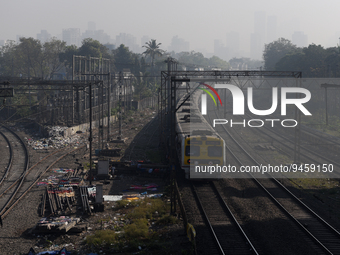 A suburban train is seen with a background of highrise buildings which are partially visible through dense smog in Mumbai, India, 18 January...