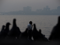 A man smokes with a background of partially seen cityscapes through dense smog in Mumbai, India, 18 January, 2023. Mumbai's Air Quality Inde...