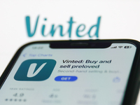 Vinted on App Store displayed on a phone screen and Vinted website displayed on a screen in the background are seen in this illustration pho...