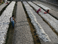 Workers set up dry fish on racks under the sunlight at Karnaphuli riverside area in Chittagong, Bangladesh on January 16, 2023.  (