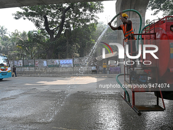 A worker spraying water on the street to control dust as the city's air quality in Dhaka, Bangladesh, on January 21, 2023 (