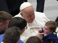 Pope Francis reacts with a child during his weekly general audience in the Pope Paul VI hall at the Vatican, Wednesday, Jan. 25, 2023.  (