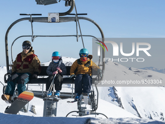 A father with his children on the chairlift to access the top of the slopes of the ski and mountain resort of Alto Campoo or Branavieja whic...