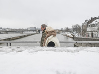 Snow in Maastricht with cold weather. Daily life and general view scenes of the river bank, houses and the bridges while people walk in the...