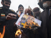 Iranian worshippers burn a portrait of the French President Emmanuel Macron, in a protest after Tehran's Friday prayers ceremonies at the Im...