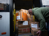 

A volunteer is seen carrying loaded boxes of medical supplies into a bus at the parking lot in Niehl, Cologne, Germany, on January 27, 202...