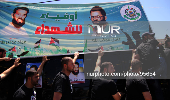 RAMALLAH, PALESTINE -April 30, 2014: Palestinian mourners attend the funeral of the two Hamas members Adel and Imad Awadallah (on the billbo...