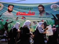 RAMALLAH, PALESTINE -April 30, 2014: Palestinian  girls waking beside billboard for two Hamas members Adil and Imad Awadallah, who was repor...