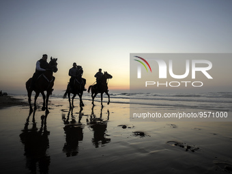 Palestinians men ride on their horses during sunset on Gaza beach, on February 10, 2023. (