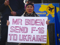A woman holds a banner 'Mr Biden Send F-16 To Ukraine' during a daily demonstration of solidarity with Ukraine at the Main Square one day ah...