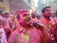 A man covered in colored powder is seen singing with a mic during Holi festival celebration in Kolkata , India , on 5 march 2023 .  Holi , a...