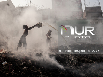 Two kids are trying to put out the fire in a dump yeard. The smoke is polluting the environment as well as the air which is very injurious t...