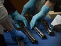 Museum staff presents muskets and other artifacts in a repatriation ceremony for the return of a cache of fifty historic weapons recovered b...