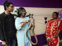 Students play with a snake at the Teacher-Student Centre of Dhaka University as they experience traditional festivals of rural Bengal at a d...