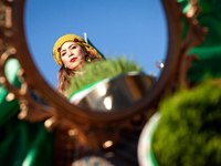 A woman in traditional dress is seen in a mirror on the haft-seen table at a Nowruz celebration on the National Mall. The holiday has its ro...