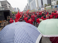 Some demonstrant use umbrella to shield from heat during the demonstration rally. As part of the May Day 2014 celebrations, 120,000 workers...