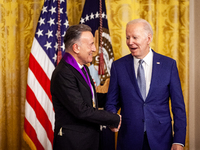 President Joe Biden shakes hands with Bruce Springsteen after awarding him the National Medal of the Arts during a White House ceremony givi...