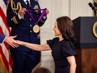 Julia Louis-Dreyfus takes President Biden's hand as she arrives on stage to receive the National Medal of the Arts.  The White House present...