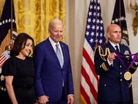 President Joe Biden and Julia Louis-Dreyfus stand on stage while the citation is read for her National Medal of the Arts award during a Whit...