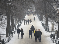People enjoy an afternoon walk in Krakow's Planty Park as the temperature remains below 0 degrees Celsius, on the day that Poland celebrates...