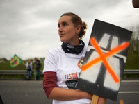 A woman holds a placard against the planned A69 highway during the 12km march. More than 8000 protesters marched 12km against the planned A6...