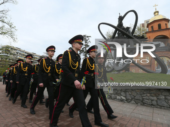 Ukrainian cadets attend a commemoration ceremony marking the 37th anniversary of the Chernobyl disaster next to a memorial to firefighters a...