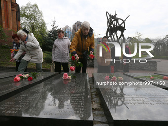 People lay flowers to a memorial to firefighters and workers, who died following the Chernobyl Nuclear Power Plant disaster, during a commem...