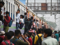 People board an overcrowded train at a railway station in Ghaziabad, Uttar Pradesh, on the outskirts of New Delhi, India on April 28, 2023....