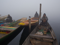 SRINAGAR, INDIAN ADMINISTERED KASHMIR, INDIA - JANUARY 13: Kashmiri boatmen wait for the people on the dock during a cold foggy day on Janua...
