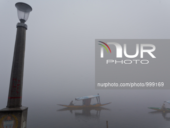 SRINAGAR, INDIAN ADMINISTERED KASHMIR, INDIA - JANUARY 13: Kashmiri boatmen row their boats during a cold foggy day on January 13, 2016 in S...