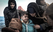 A young refugees pictured crying after his family and nearly 50 others safely arrived at t...