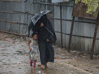 A woman with her child move to take shelter in the Cyclone Shelter on Shahpori island on the outskirts of Teknaf, on May 14, 2023, ahead of...