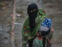 A woman with her child move to take shelter in the Cyclone Shelter on Shahpori island on the outskirts of Teknaf, on May 14, 2023, ahead of...