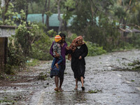 Bangladeshi people move to took shelter in the Cyclone Shelter in Shahpori island on the outskirts of Teknaf, on May 14, 2023, ahead of Cycl...