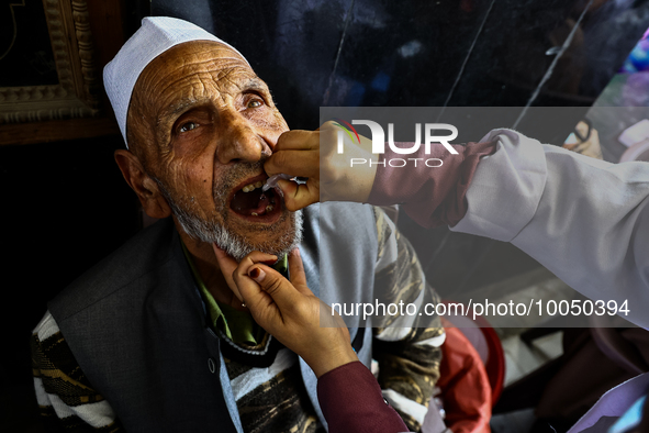 An elderly Muslim receive drops before leaving for Hajj during Hajj Vaccination program at SDH Sopore District Baramulla Jammu and Kashmir I...