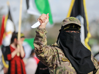 A woman dressed in military fatigue raises a knife as she joins supporters of the Islamic Jihad in a rally in Gaza to commemorate armed comm...