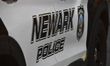 Newark police logo and signage on a Newark police vehicle at the crime scene. Two people s...