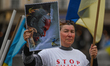 KRAKOW, POLAND - MAY 20, 2023: A Ukrainian activist holds a poster featuring Russian Pres...