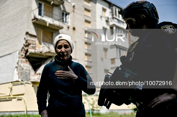 ZAPORIZHZHIA REGION, UKRAINE - MAY 18, 2023 - A local resident talks to rescuers outside a residential building damaged as a result of shell...